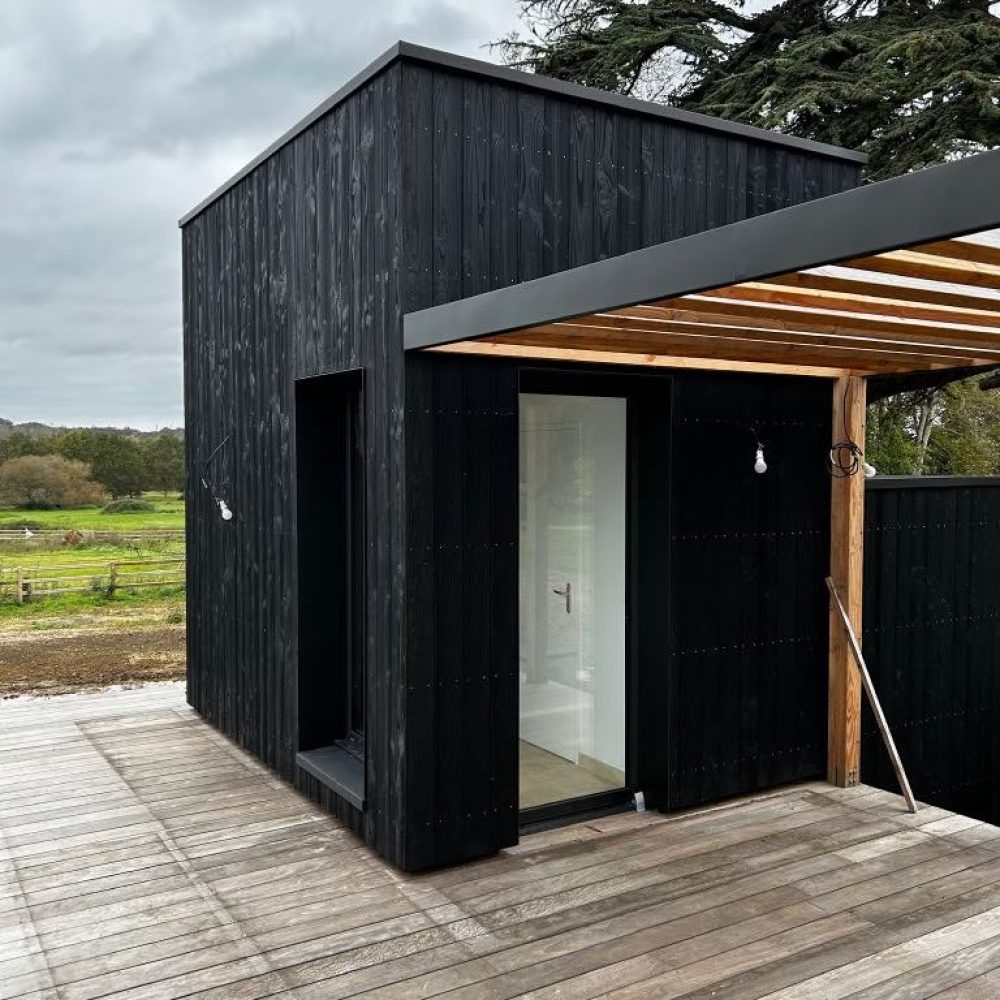 Pool house réalisé par un architecte d'intérieur et maitre d'oeuvre. Maison piscine en bois brulé