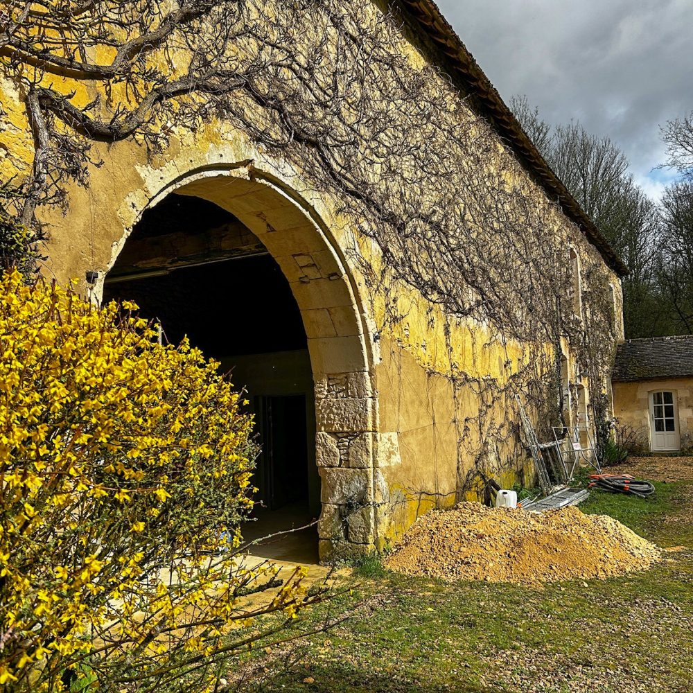 Photo d'une grange extérieure avec arche et vignes en rénovation