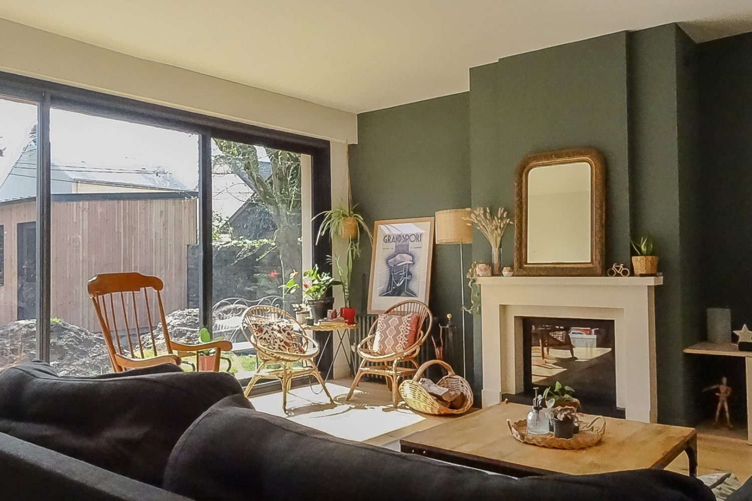 Salon d'une maison rénové authentique et a caractére. Avec un mur peint en vert